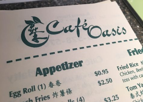 The Cafe Oasis menu sits on the counter in front of the register.