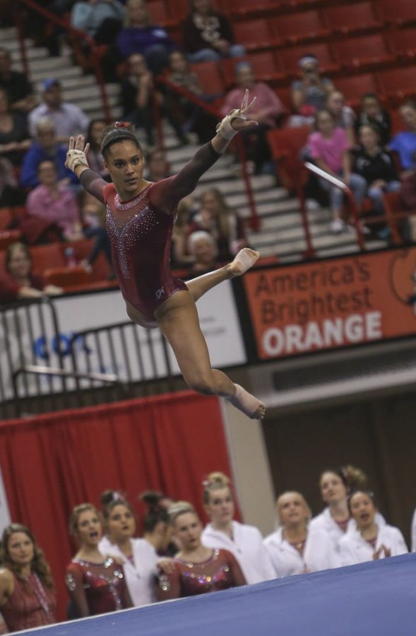 Junior AJ Jackson jumps and strikes a pose during her floor routine, Feb 10. Jackson scored a 9.975 for this event. Paxson Haws/The Daily