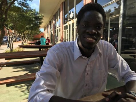 Robert Bob Okello, junior from Uganda and president of The United World, sits outside of Cate Center and discusses his views on the declining number of international student enrollments at The University of Oklahoma.