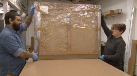 Kristi Wyatt, preparator and associate exhibition designer, and Christopher Mackie, assistant preparator, wrap a painting and prepare to place it in a cardboard container. The painting joined a collection of artwork that was sent to Dallas for conservation Monday.