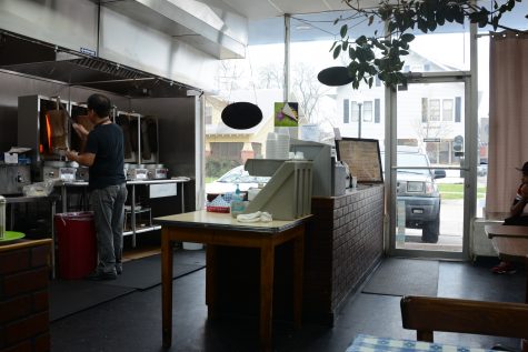 A cook is slicing meat on a vertical spit at the Greek House restaurant. The kitchen in Greek House is unique: Instead of being hidden in the back of the building, the cooks greet the visitors from behind the counter.
