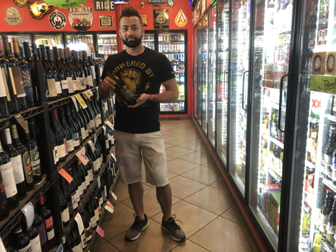 Daniel Joshi, founder of Rosedale Market, holds his favorite 
wine selection from the store inventory on March 22, 2018,
 in Austin, Texas. The corner store has stocked over 900 
variations of wine and champagne. 
