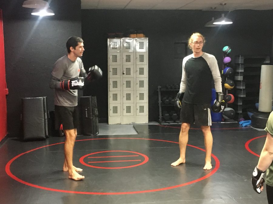 James White, owner of James White Fitness (left), and Austin Plank, a director of Second Wind Coffeehouse (right), perform Muay Thai combinations at a Nov. 15 session for Second Wind baristas. White is a former mixed martial arts fighter who offers free Muay Thai lessons to Second Wind baristas at 6 p.m. every Thursday. 