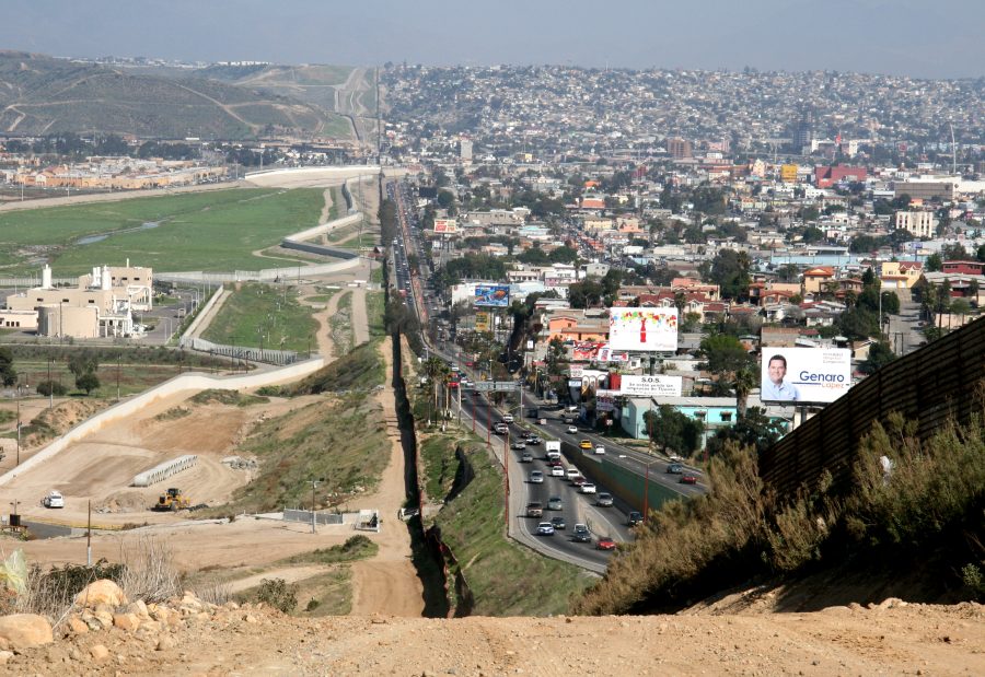 A small fence separates densely populated Tijuana, Mexico, right, from the United States in the Border Patrols San Diego Sector.  Construction is underway to extend a secondary fence over the top of this hill and eventually to the Pacific Ocean.
