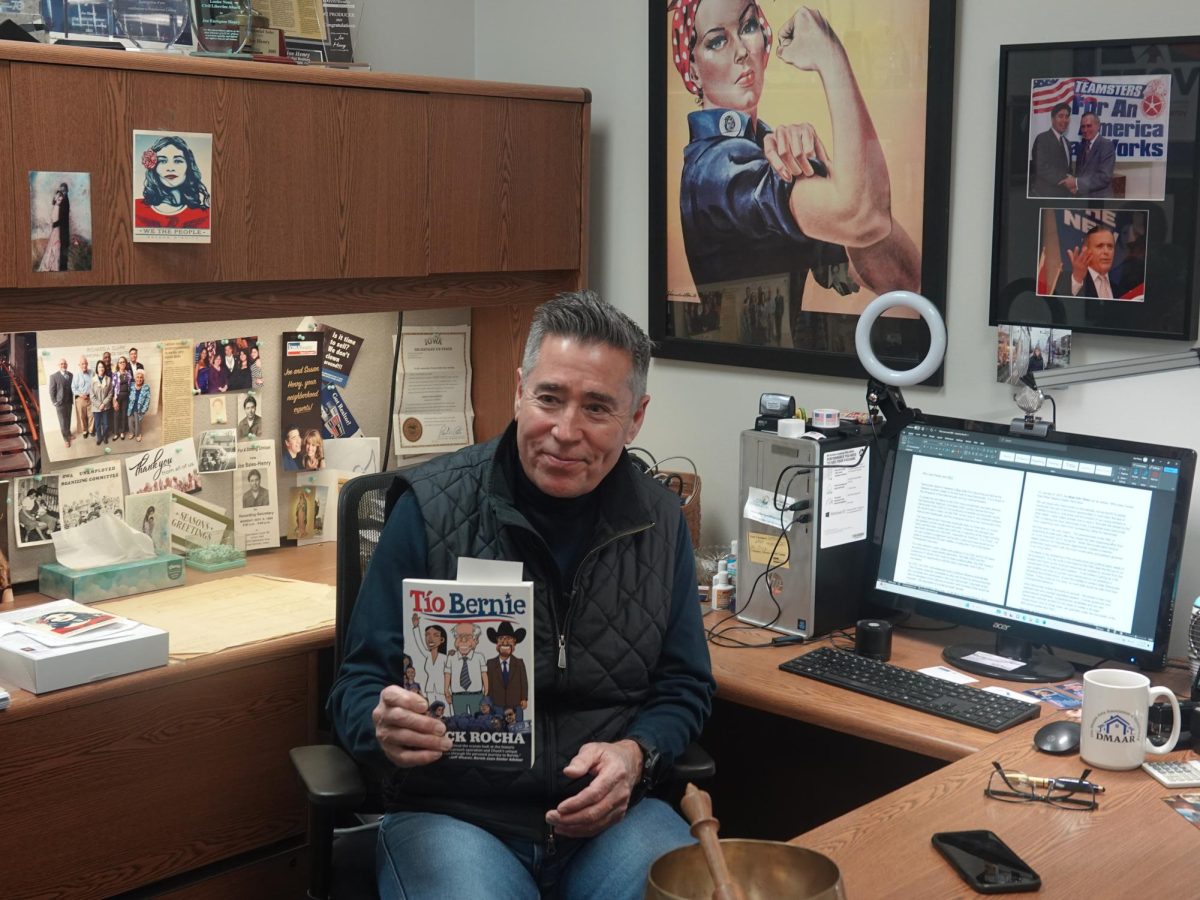 Latino activist Joe Henry holds a copy of Tio Bernie by Chuck Rocha.  Kevin Engleson photo/Gaylord News 
