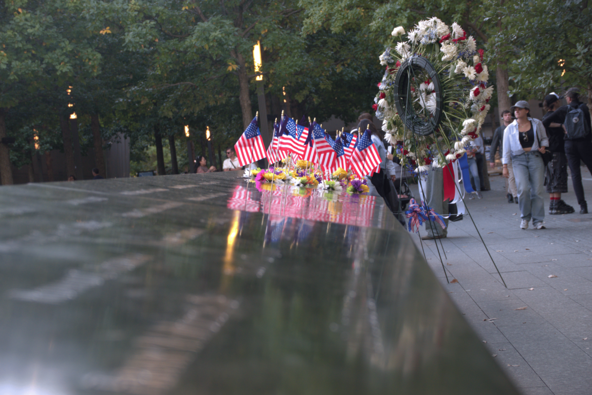 American Flags, placed in the carved-out names of those who died during the September 11, 2001, terrorist attacks on the World Trade Center, line a wall of a waterfall at the 9/11 Memorial in New York. Gaylord News/Kevin Eagleson