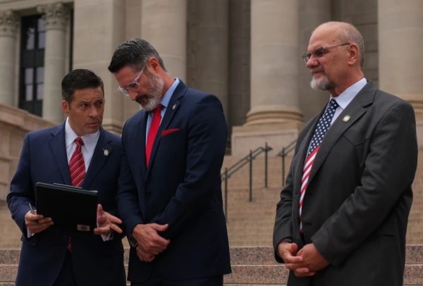 Oklahoma State Sens. Shane Jett (R-Shawnee) and Dusty Deevers (R-Elgin) confer at announcement of formation of the Oklahoma Freedom Caucus. Sen. Dana Prieto (R-Tulsa) looks on.  (Photo courtesy KOSU)
